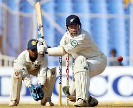 New Zealand batsman Craig McMillan attempts a sweep shot as Indian wicketkeeper Parthiv Patel looks on 