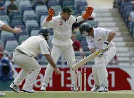 Australian wicketkeeper Adam Gilchrist exults after Zimbabwe batsman Craig Evans is clean bowled 