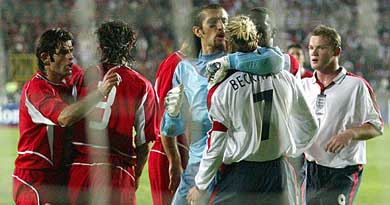 England captain David Beckham is held by Turkey goal-keeper Rustu Recber 
