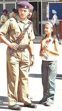 A girl requests a cop to allow her to present flowers to the visiting cricketers at the airport in Chandigarh on Monday.