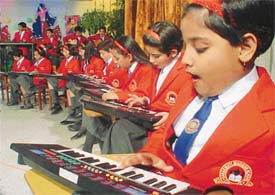 Students of Saraswati Modern School play piano as they present an item in instrumental music during annual day celebrations