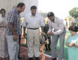 Former hockey Olympian Ashok Kumar lighting a lamp to inaugurate the CBSE Hockey Tournament, watched by Ganga School Principal Mrs Sraw and manager Sushil Kumar Gupta