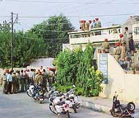 Policemen surround the house in which an armed man has taken a seven-year-old girl hostage