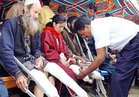 Physically challenged persons wait for Chief Minister Mufti Mohammed Sayeed to get artificial limbs at a function organised by the Waqf Board in Srinagar 