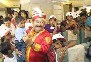 A man dressed as Air India mascot Maharaja interacts with children on board of a Boeing 747-400 aircraft in Mumbai