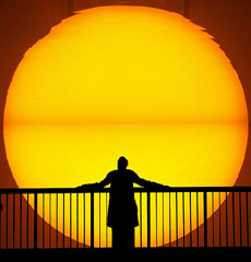 A woman is silhouetted against a giant replica of the sun on display at the Turbine Hall of London's Tate Modern art gallery 