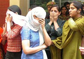 Three of the six women, who were arrested in connection with flesh trade from a hotel in Delhi, try to cover their faces at the Chanakyapuri police station in New Delhi on Friday.�