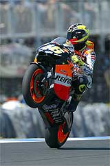 Italian MotoGP world champion Valentino Rossi lifts the front wheel of his Honda motorbike 