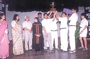 DPS Society vice-chairman Ashok Chandra giving away the trophy to the students of DPS R K Puram.