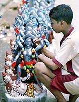 A child gives final touch to images of Kali