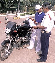A traffic policeman discussing safety measures with a volunteer during a road safety awareness programme in the Capital