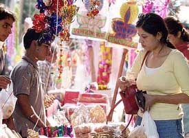 A woman purchases goodies on the eve of the Divali