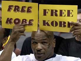Former boxing champion Mike Tyson holds up placards in support of Los Angeles Lakers' Kobe Bryant 