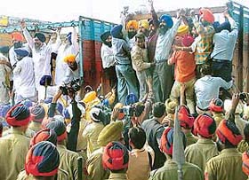 Protesters being bundled into a truck by the police apprehending law and order problem in view of the World Sikh Convention held in SAS Nagar