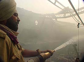 A fireman douses fire at a hosiery unit in New Kidwai Nagar, Ludhiana