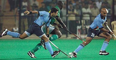 Nigerian player Josiah Timothy Tinat dribbles past India's Deepak Thakur and Len Ayiappa 