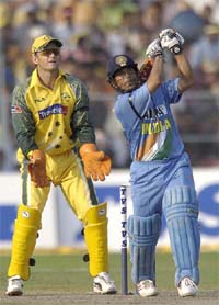 Sachin Tendulkar watches the ball after playing a shot as Australian wicketkeeper Adam Gilchrist looks on