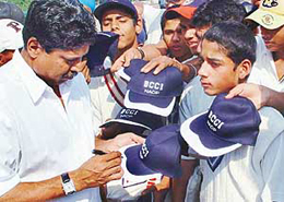 Kapil Dev distributes T-shirts and caps sent by the Cricket Board to young trainees after he inaugurated a cricket academy at the Sector 16 cricket stadium in Chandigarh on Monday.