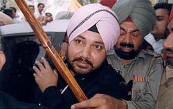 Daler Mehndi is helped out of his Mercedes Benz by an Inspector outside Sadar police station in Patiala on Monday.