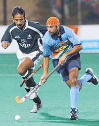 Prabhjot Singh (R) dribbles past Pakistani defender Mudassar Khan during a group hockey match at the first Afro-Asian Games in Hyderabad on Monday.