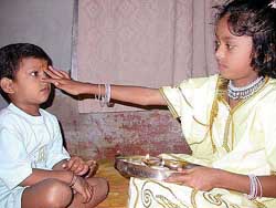 A sister applies tilak on the forehead of her brother on Bhaiya Dooj in Allahabad