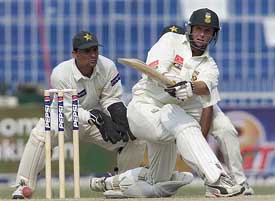 South Africa's Gary Kirstan sweeps Pakistani spinner Mushtaq Ahmed as wicketkeeper Moin Khan looks on