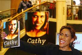 Olympic champion athlete Cathy Freeman holds up her book at a central Sydney department store 