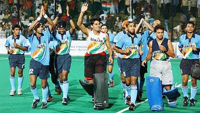 Indian hockey team members wave to the crowd after defeating Pakistan 4-2 