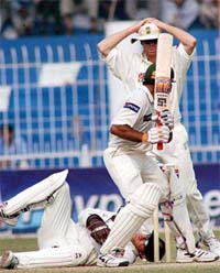 South African wicketkeeper Mark Boucher lies on the ground after he dropped Pakistani batsman Taufeeq Umer as Shaun Pollock holds his head in disappointment