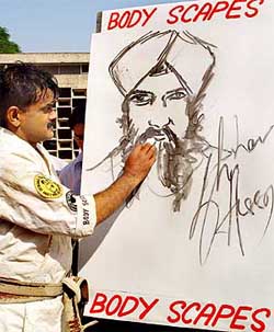 Shihan paints the portrait of a Sikh gentleman with the same hand soon after breaking his record at the Government Art College campus