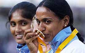 Soma Biswas watches compatriot J.J. Shobha kiss her gold medal at the victory ceremony