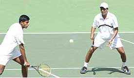 Mahesh Bhupathi  watches as Rohan Bopanna returns a ball during the men's doubles finals at the Ist Afro-Asian Games