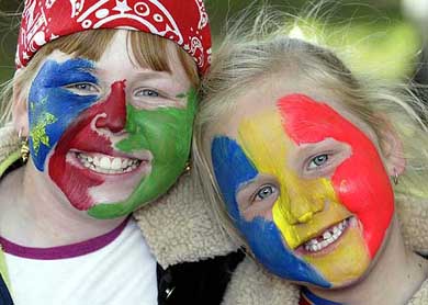 Sisters Nicole, painted with Namibia colours, and Kelcy Tudor with Romania colours cheer their teams during a group match between Romania and Namibia 