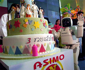 Honda's Asimo robot waves after cutting his birthday cake in Bangkok 