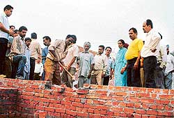 Municipal Corporation workers demolish a structure 