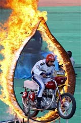 An Indian army 'Dare-Devils' motorcycle rider rides through a ring of fire during the closing ceremony of the first Afro Asian Games