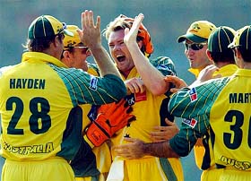 Australia�s Brad Williams celebrates with teammates after claiming the wicket of New Zealand's Craig McMillan 