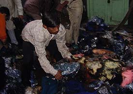 Labourers try to retrieve hosiery goods after a fire broke out in a hosiery unit 