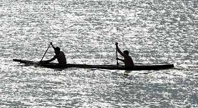 Members of Brazil's Rikbatsa nation paddle their handmade canoe along River Tocantins 