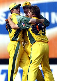 Australian bowler Ian Harvey is hugged by teammates Ricky Ponting and Damien Martyn on taking the wicket of New Zealand captain Stephen Fleming