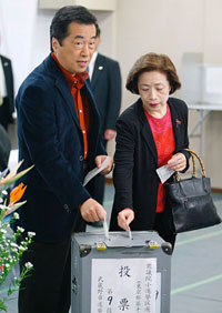 Naoto Kan, head of Japan's biggest opposition Democratic Party, casts his ballot with his wife Nobuko