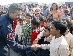 Wing Cdr S. Prabhakran interacts with schoolchildren after the air show