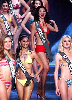 Miss Afghanistan Vida Samadzai, the first Afghan in three decades to take part in a beauty contest, smiles as she stands beside other candidates during the swimsuit competition on the coronation night of the Miss Earth 2003 beauty pageant in Manila 