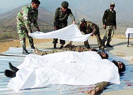 Army jawans cover the bodies of three Lashker-e-Toiba militants killed in an encounter
