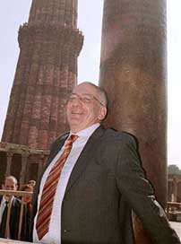 Swiss President Pascal Couchepin tries to grip the 'fortune' pillar at the Qutub Minar complex in New Delhi