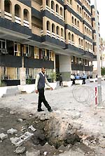 A man walks past the site of a bomb blast outside a Baghdad courthouse