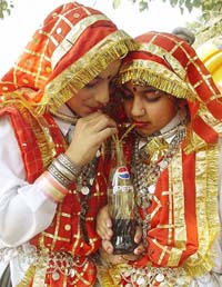 Two children share a cold drink during a cultural programme in Ambala
