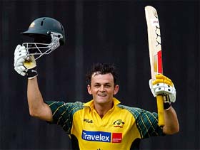 Australian batsman Adam Gilchrist raises his bat to the cheers of the crowd on scoring a century against India in Bangalore