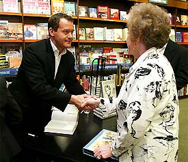 Paul Burrell (left), former butler and confidant of Princess Diana, greets fan Florence Quinn, the first in the line to have a copy of his book, �A Royal Duty�