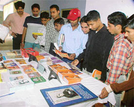 Students of Government College for Boys take a keen interest in literature on Swami Vivekananda at an exhibition after a Sarv Dharam Conference